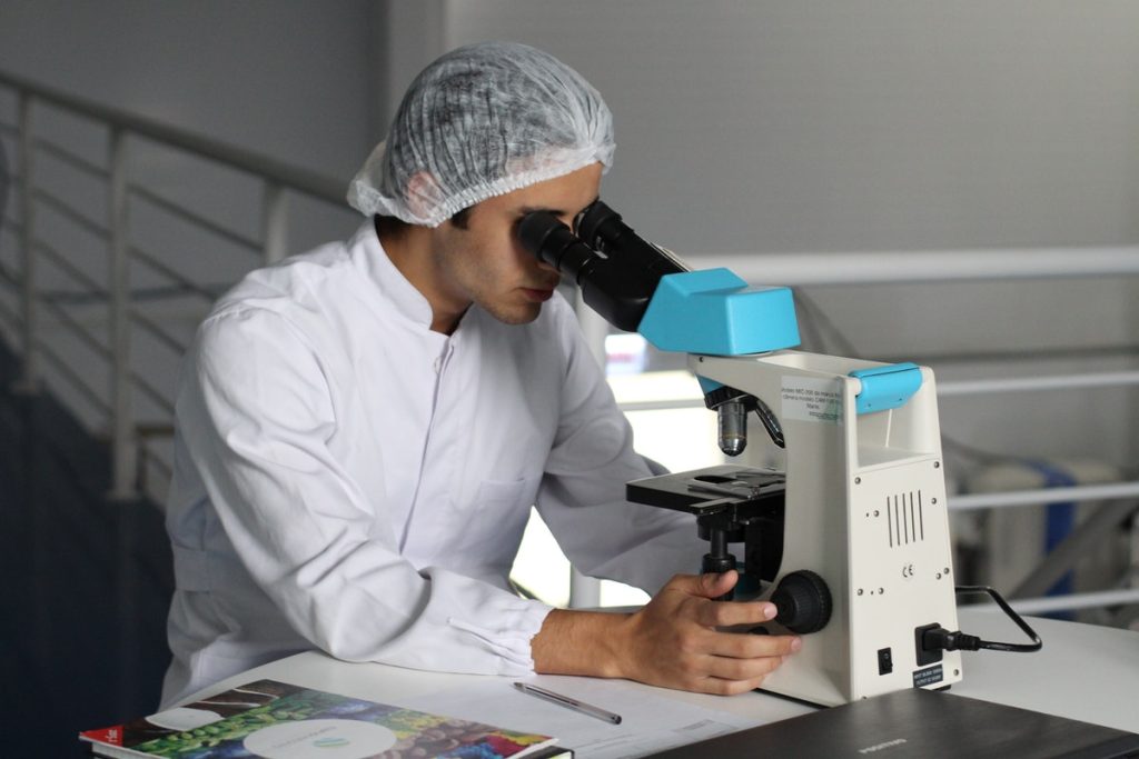 man looking at a microscope