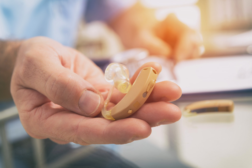 A nurse's hand holding a hearing aid