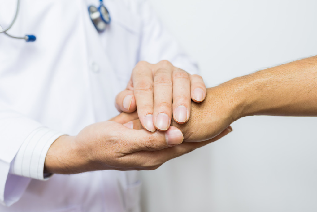 doctor holding a patient's hand in assurance