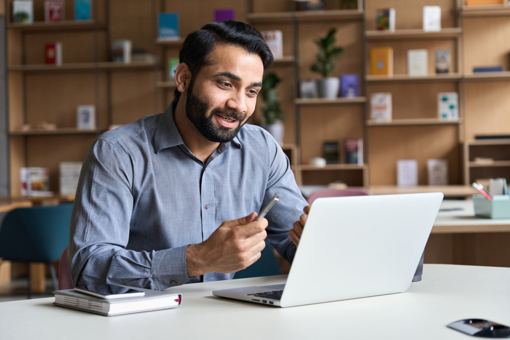 a man teleworking while looking at his laptop