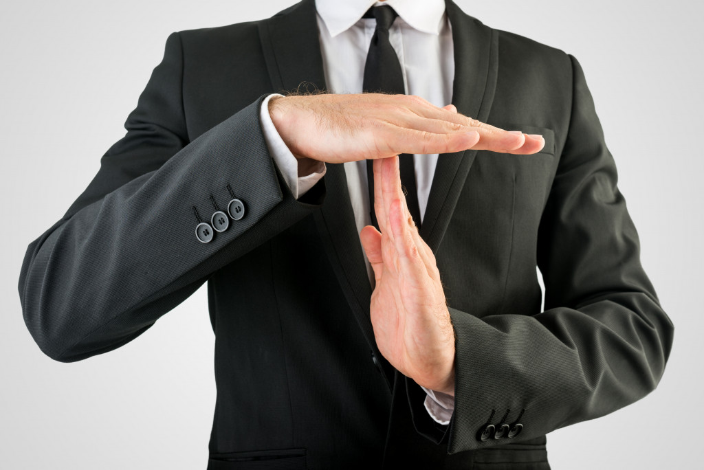 a businessman showing time out sign